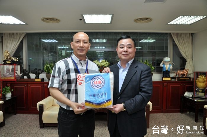 邱議長頒贈議會會旗給魯李仁理事長。