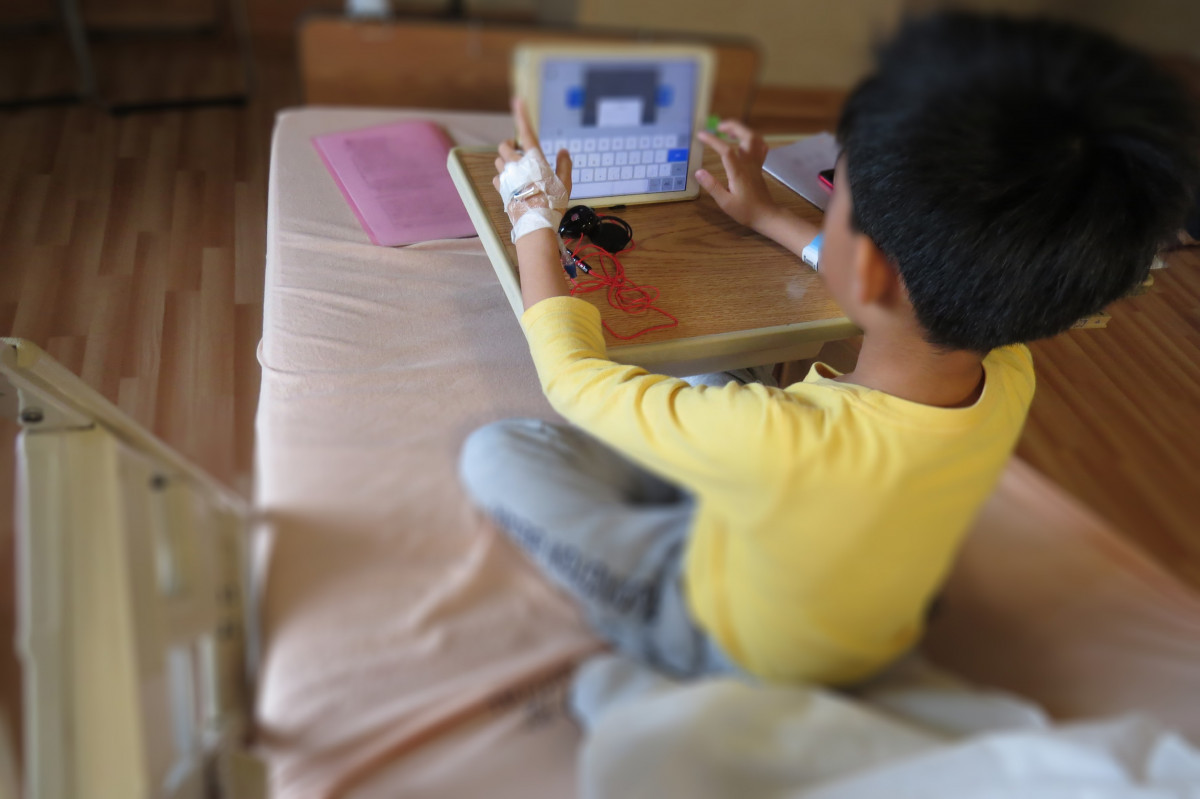男童病情好轉後把握時間透過視訊完成學校課程。