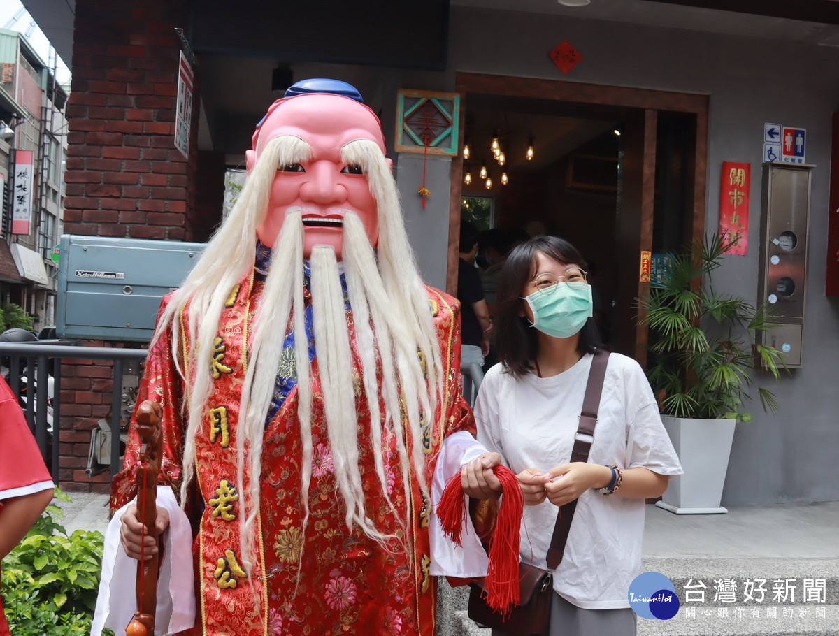 不分男女自月老手中取紅線祈祝好運連連。（記者扶小萍攝）