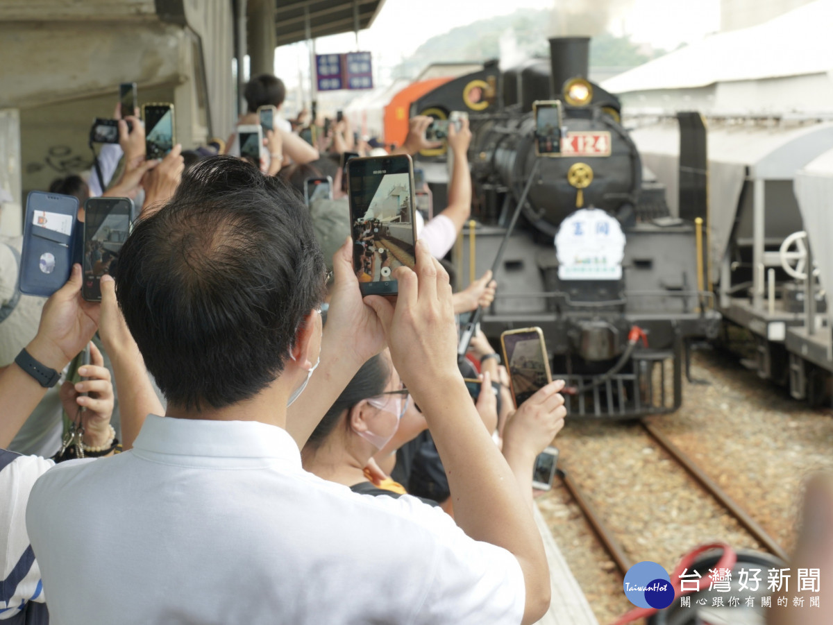 張善政和現場的鐵道迷一同迎接CK124的到來，拿出手機按下快門。