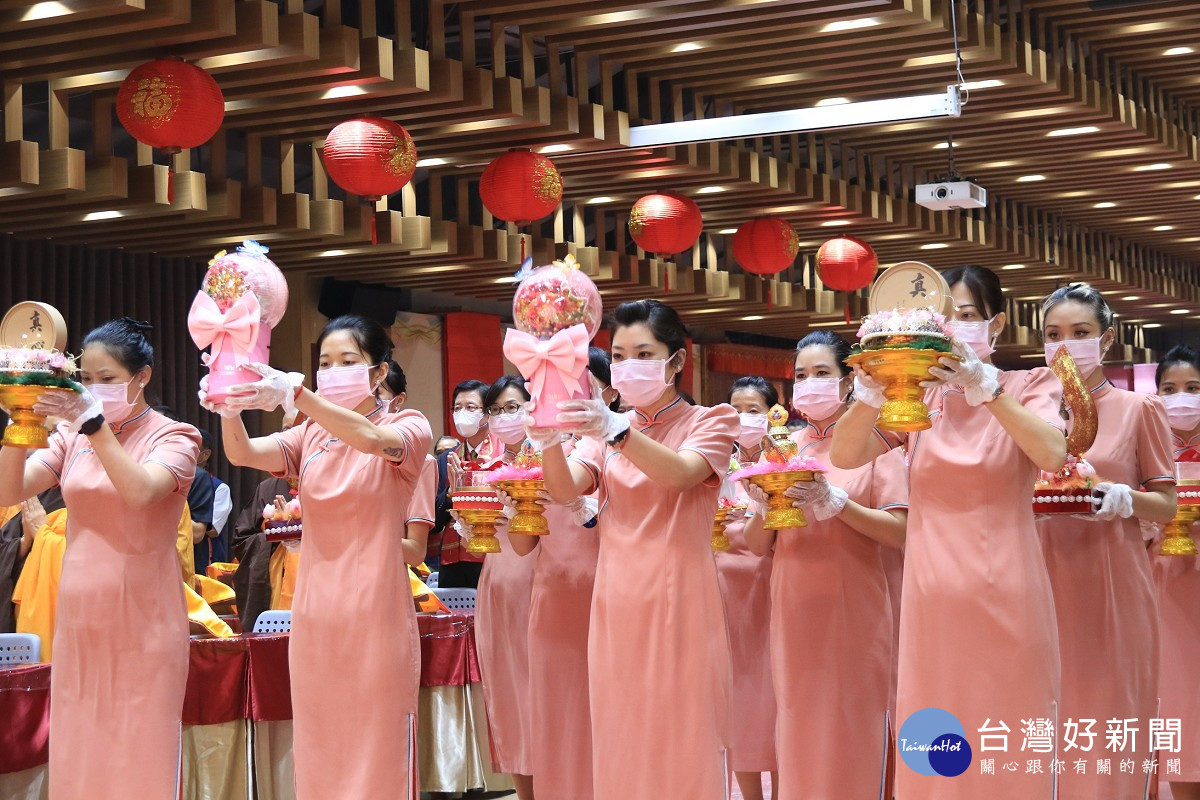 「全球獻供」主場隊伍身著粉橘色旗袍，以花、果、燈、經文、寶瓶、海螺、舍利塔等十供養，莊嚴會場
