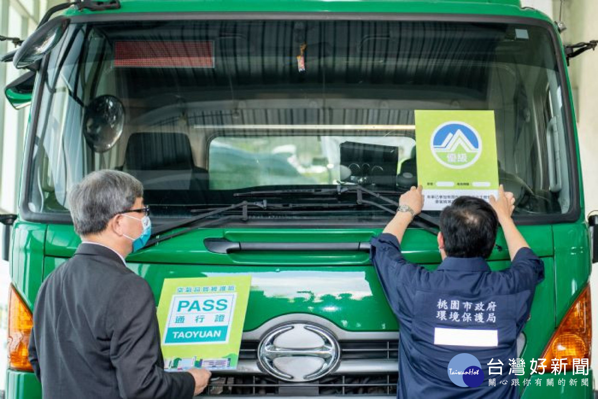 市長為通過檢測的柴油車輛掛上排煙檢測合格證明。