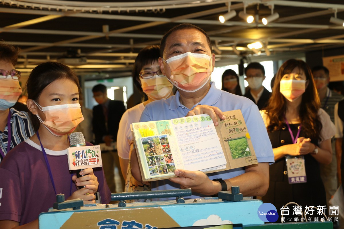 侯友宜展示稻米小書內容  左為淡水區新市國小6年級學生林恩莉