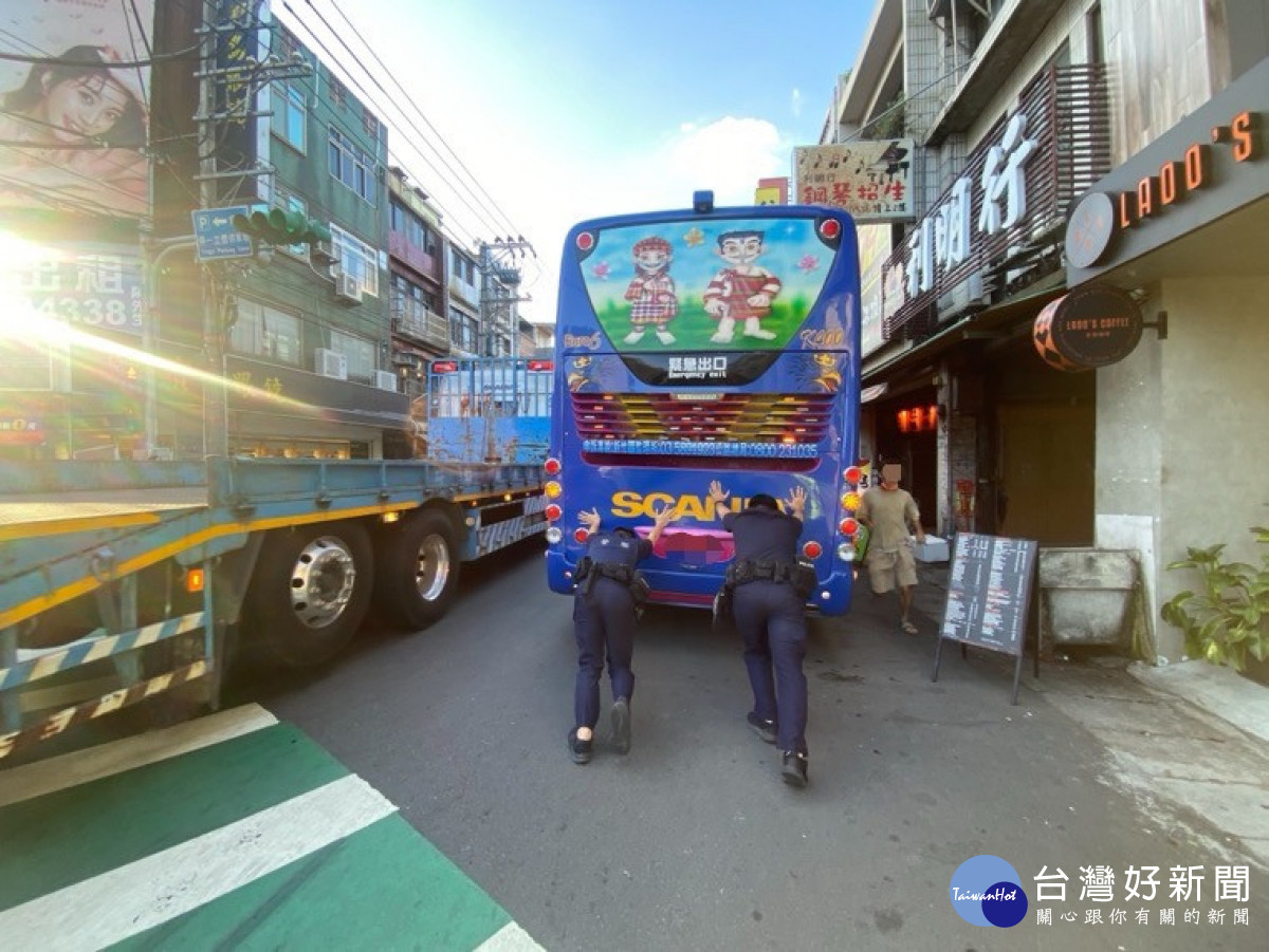 員警與熱心民眾合力將遊覽車推到路邊停靠即時排除障礙。