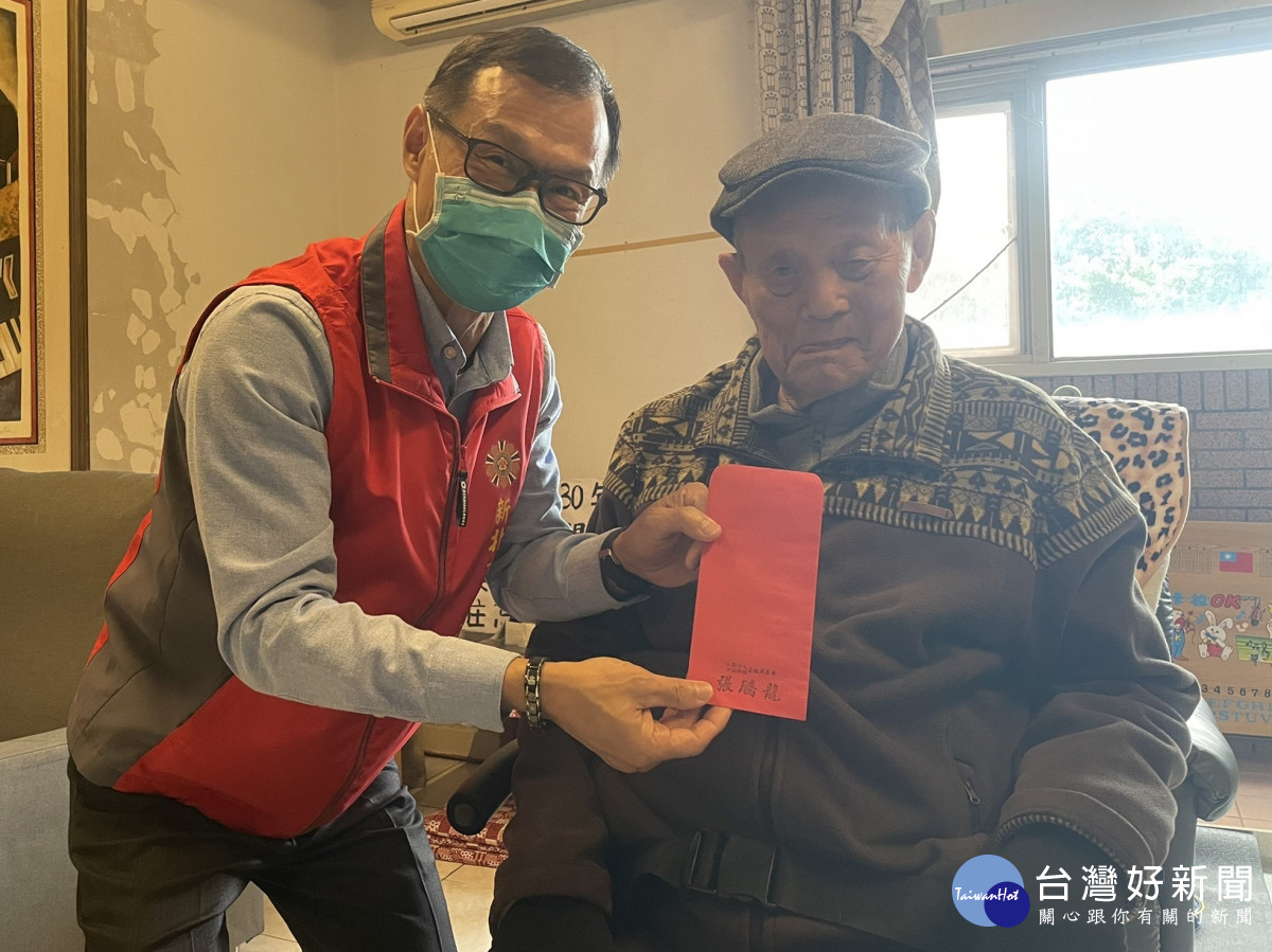 吳伯伯(右)戴上他喜歡的帽子，從臥房出來接受周處長(左)轉贈慈善會的關慰禮金