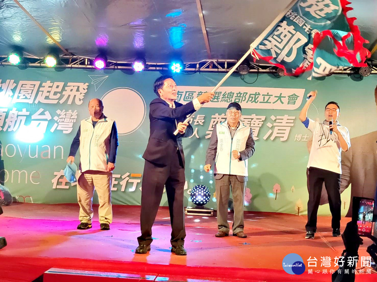 鄭寶清接受榮譽主委黃金春授的戰旗在舞台上揮舞