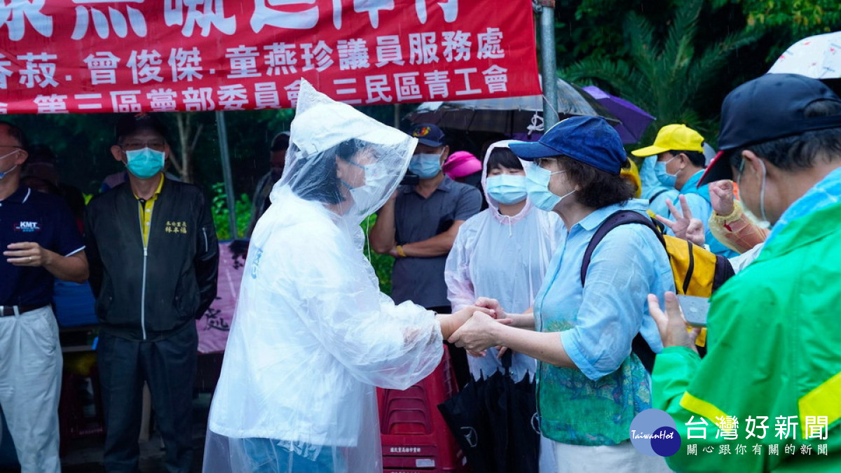 ▲柯志恩穿著雨衣勤跑拜票，汗水如雨般下。