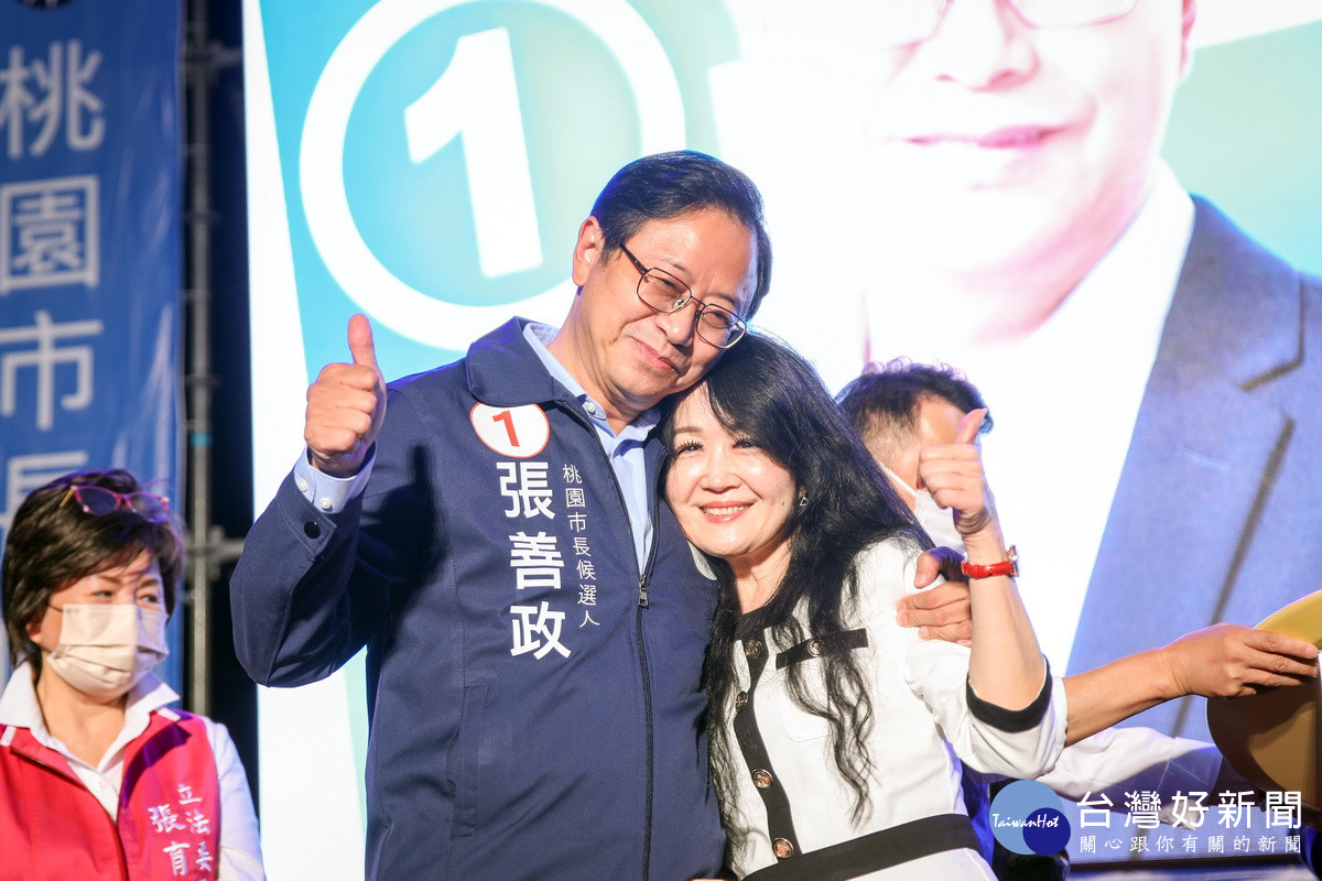 桃園市長當選人張善政牽著妻子張琦雅上台發表勝選感言。