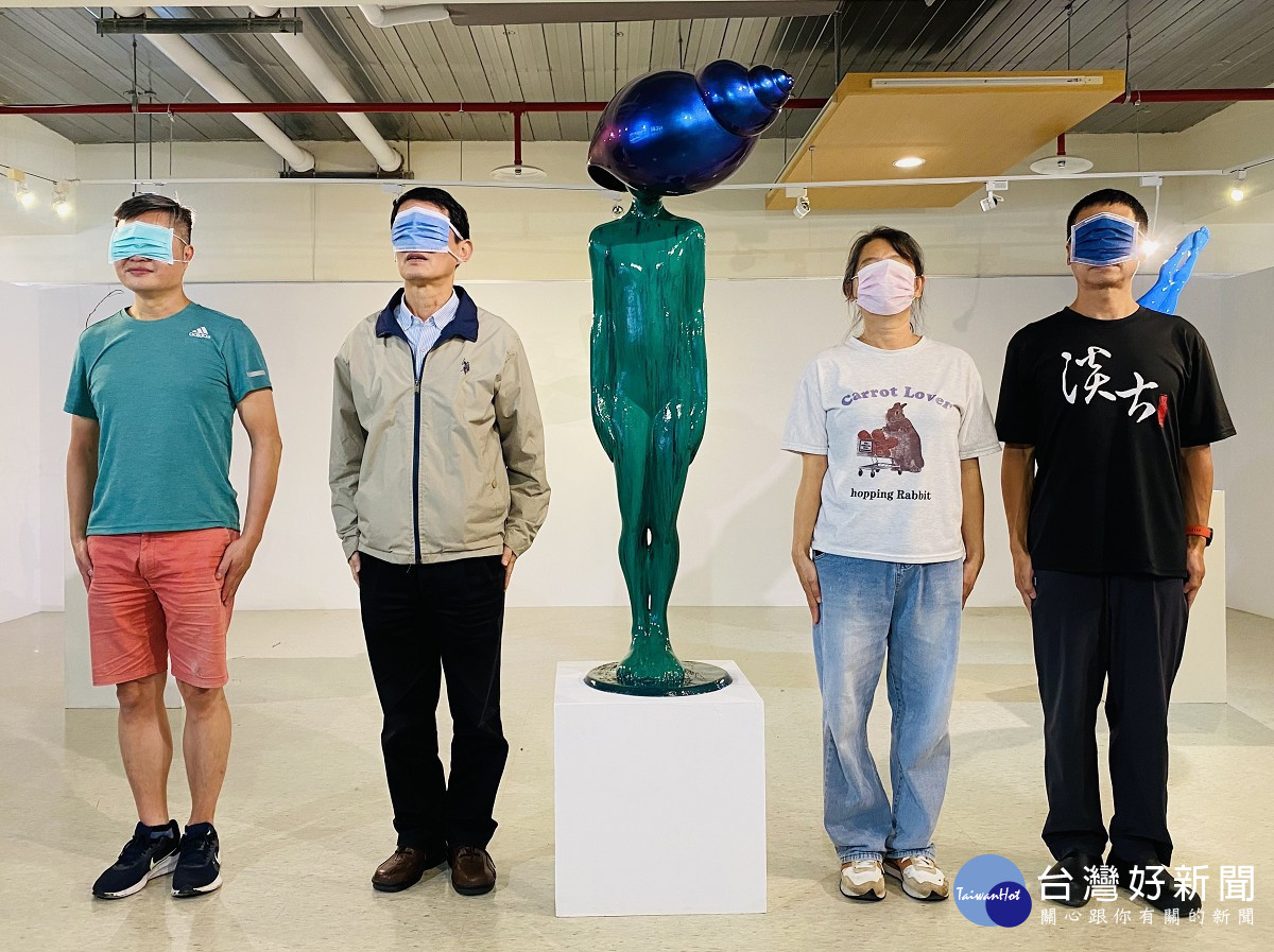 淡古駐村藝術家簡俊成（左1）與參觀民眾以口罩遮臉與作品《寂靜的心》合影，留下有趣的畫面