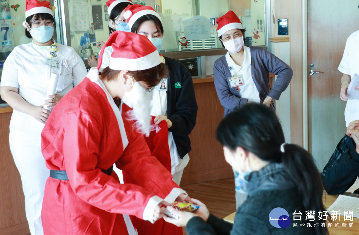 職能治療師蔡依君扮成耶誕老公公分送糖果餅乾。