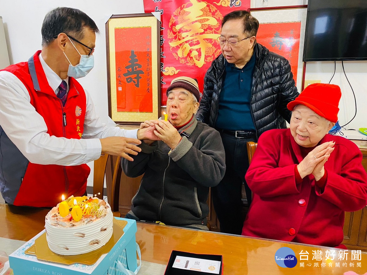 周興國處長(左)請蕭爺爺(中)吹蠟燭與蕭奶奶及公子一同慶賀百歲