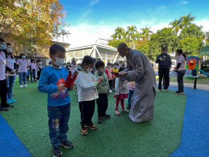 琉璃山東方淨苑住持發放紅包給集集鎮立幼兒園的10名幼童。