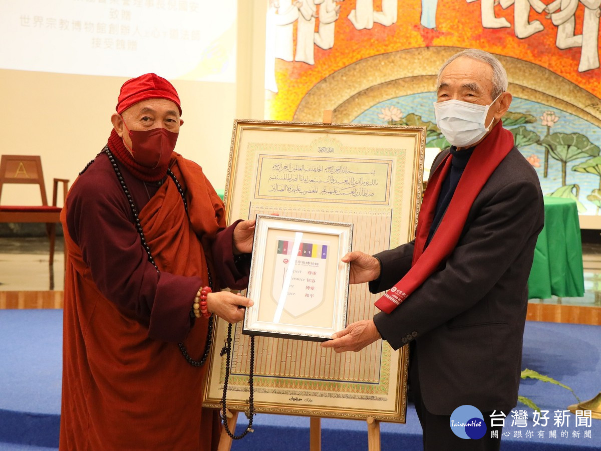 靈鷲山開山住持、世界宗教博物館創辦人心道法師（左），回贈世界宗教博物館錦旗給中國回教協會榮譽理事長倪國安（右），展現跨宗教的情誼