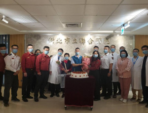 新北市立聯合醫院醫療團隊暨新北市消防局第三救災救護大隊，為蔡震潭（中）歡慶康復成功出院，準備大蛋糕賀「重生」