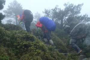 登山遇到降雨，請穿上兩截式雨衣褲，妥善固定背包套，做好防水(玉管處提供)