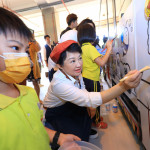 盧市長頭戴畫家帽手拿畫筆-帶領學童將公車線稿填上五彩顏料