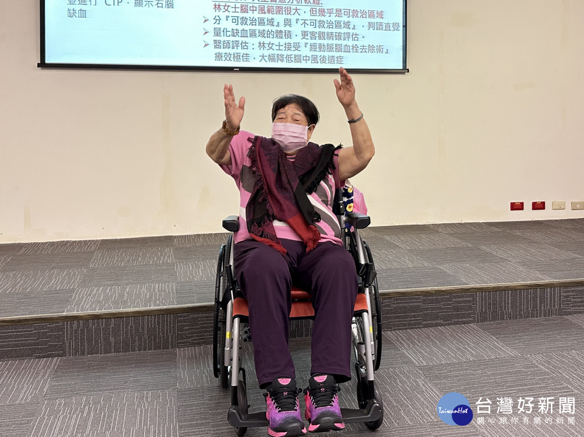 林女士今天出席記者會並高舉雙手顯示自己復健的成果。中國附醫提供