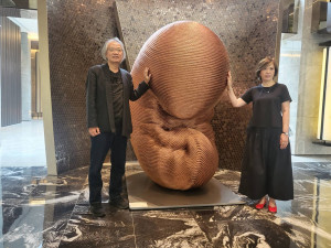 亞昕集團土地顧問「張維珍」（右）以及建築師許榮江（左）一起為於「亞昕丰學館」展出的藝術作品作介紹。