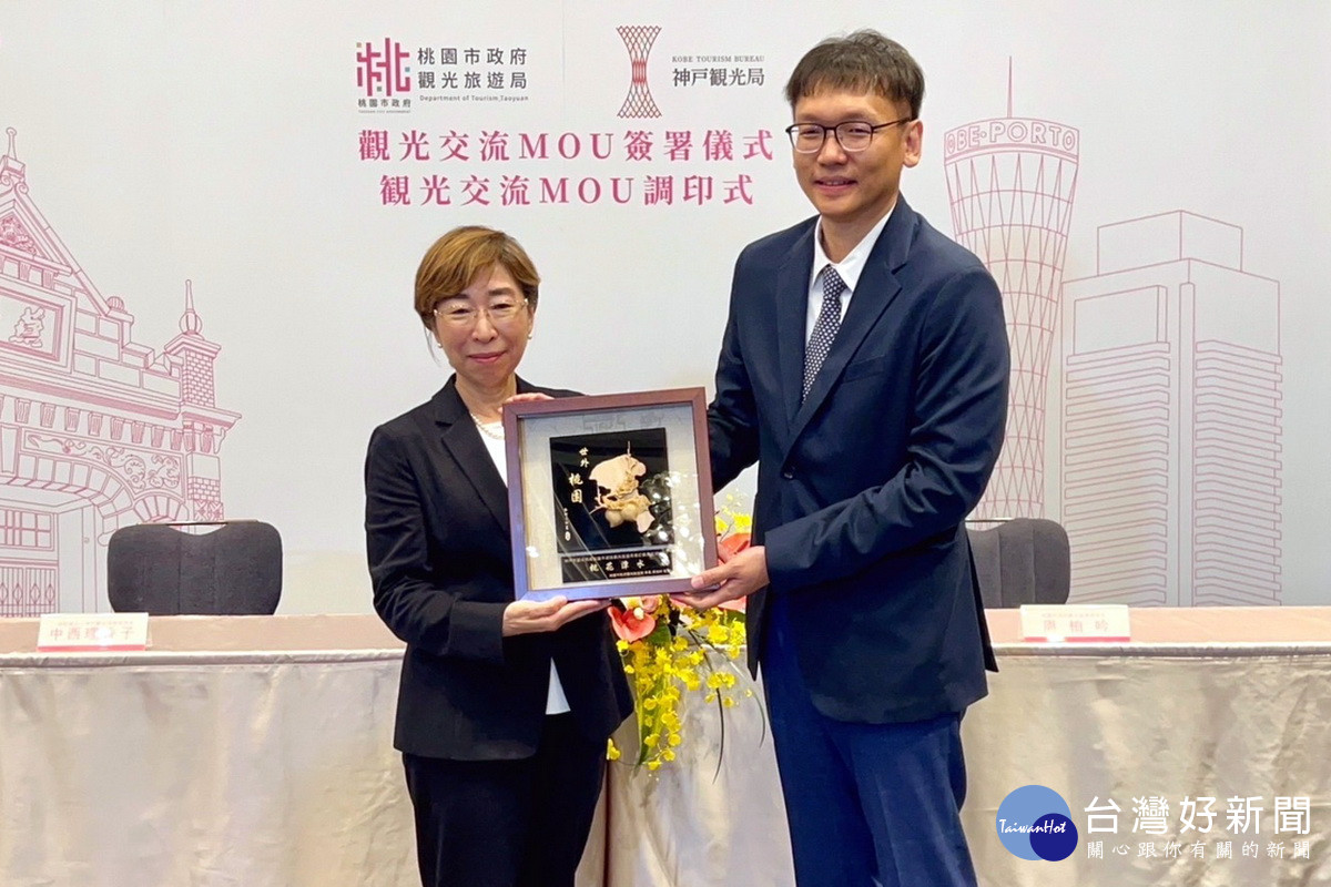 桃園市政府觀光旅遊局長周柏吟與神戶觀光局專務理事中西理香子互贈紀念品。