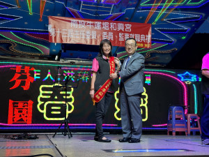 傅中將為廖主委披彩帶。（記者扶小萍攝）