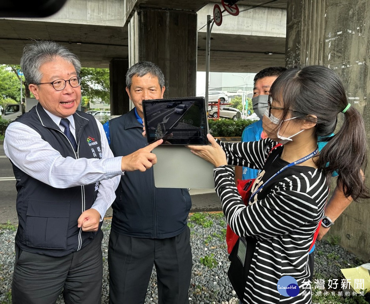 台中市環保局長陳宏益，透過路口監控器即時影像說明路口監視器監測汽車亂丟垃圾的精準度。(圖/記者賴淑禎攝)