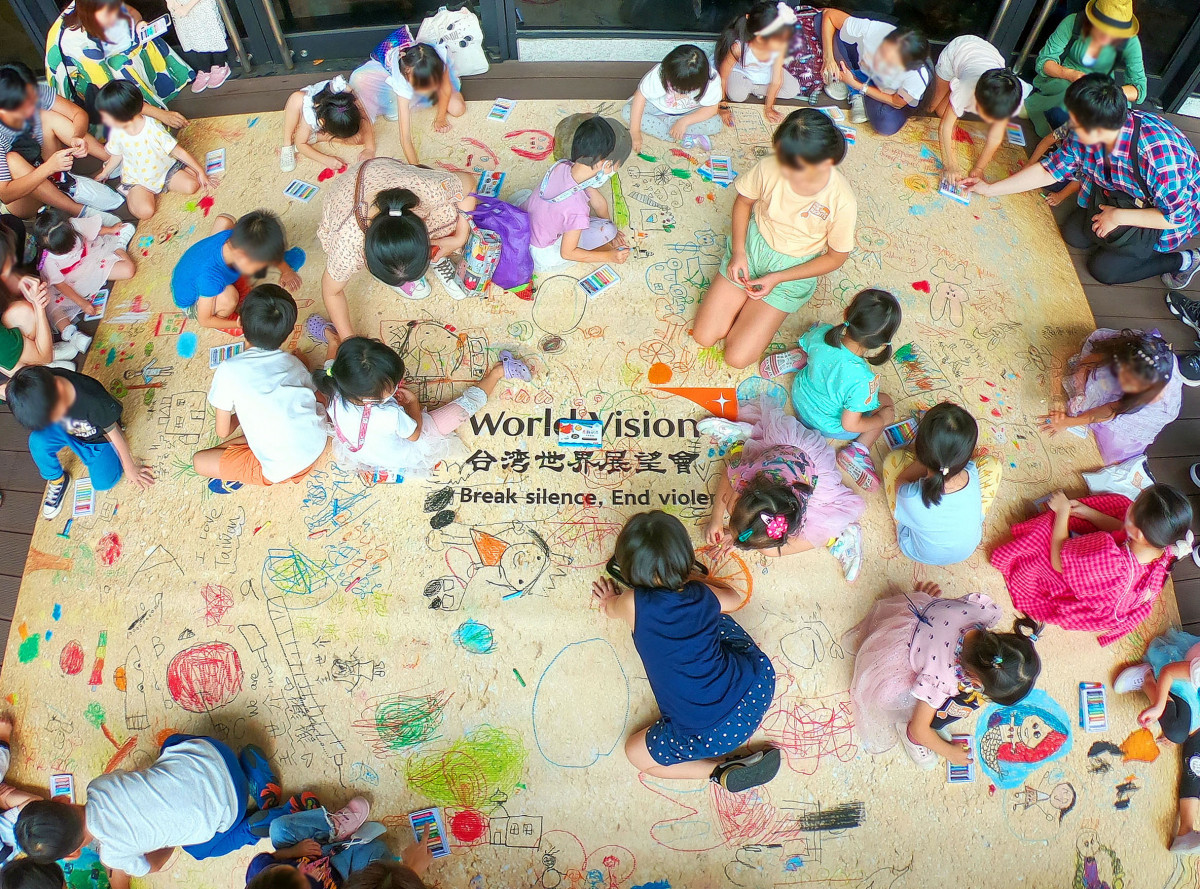 全場大小朋友在地板上自由聯合作畫，童言童語地寫下祝福(台灣世界展望會提供)