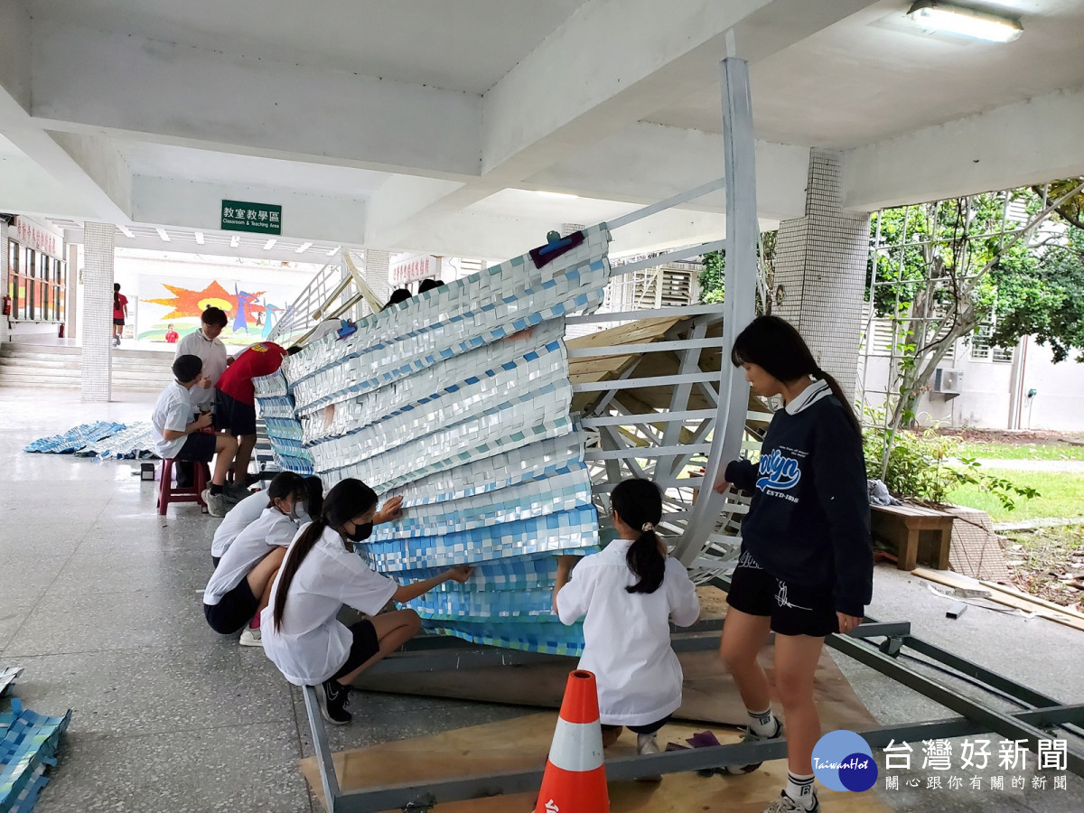 學生將編織的鋁片固定在船身骨架上，要將水平編織固定在弧形的船身上，別具挑戰。<br /><br />
