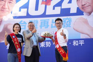前總統府資政廖了以致贈江啟臣象徵包中的包子與粽子。