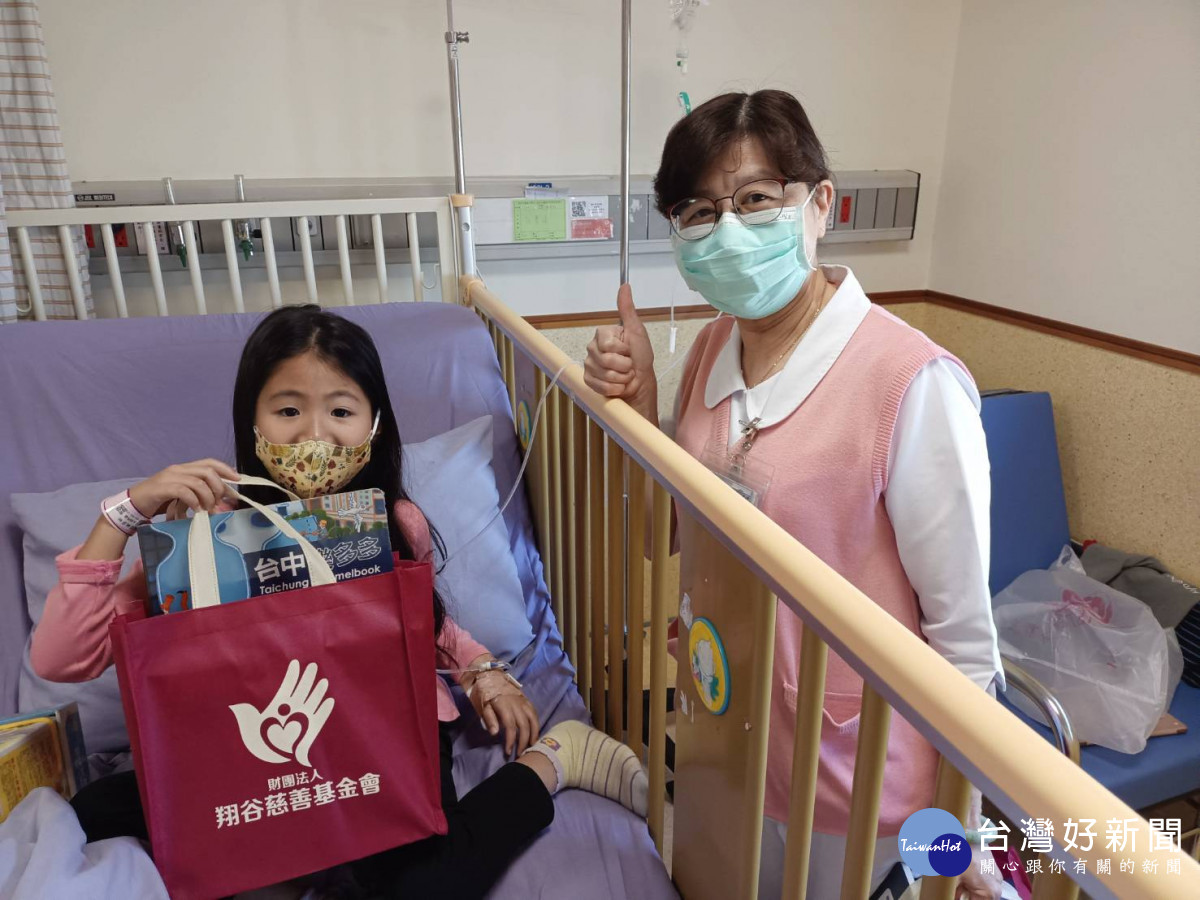 翔谷慈善基金會到童醫院，李宜靜護理長協助送禮物給病童。