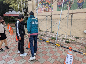 台中市議員周永鴻與圳堵里里長鄭秀燕（左）檢視磁磚剝落情形。