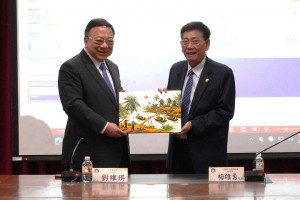 越南平陽省政府常務部梅雄勇主席（左）贈送越南畫給中華大學校長劉維琪（右）。