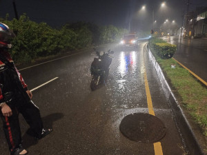滂沱大雨推移人孔蓋致生交通事故，警發現即時處置。