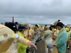 臺中港保育放流活動參與人員合力傳遞魚苗放流。