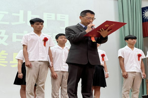 陳宥軍同學(左)為畢業証書授証代表，吳俊憲校長宣讀証書內容。