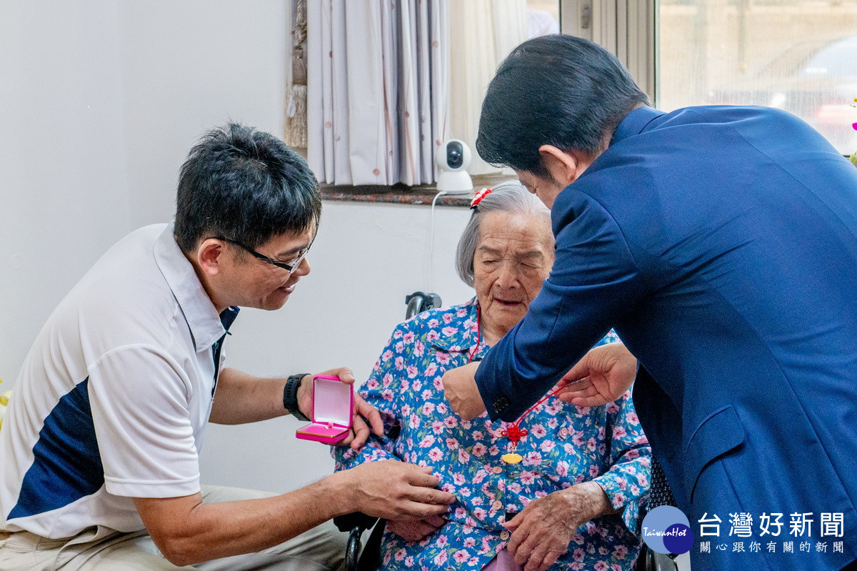賴清德總統親自為百歲人瑞葉徐秀英戴上金鎖片。<br />
