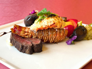 沐青餐廳晚餐限定的「初見心動雙人套餐」，主餐可選慢烤宜蘭櫻桃鴨胸或勃根地紅酒醬紐約客牛排，每份套餐還加贈頂級加勒比海龍蝦尾，為饗宴增添奢華質感。圖片提供／業者