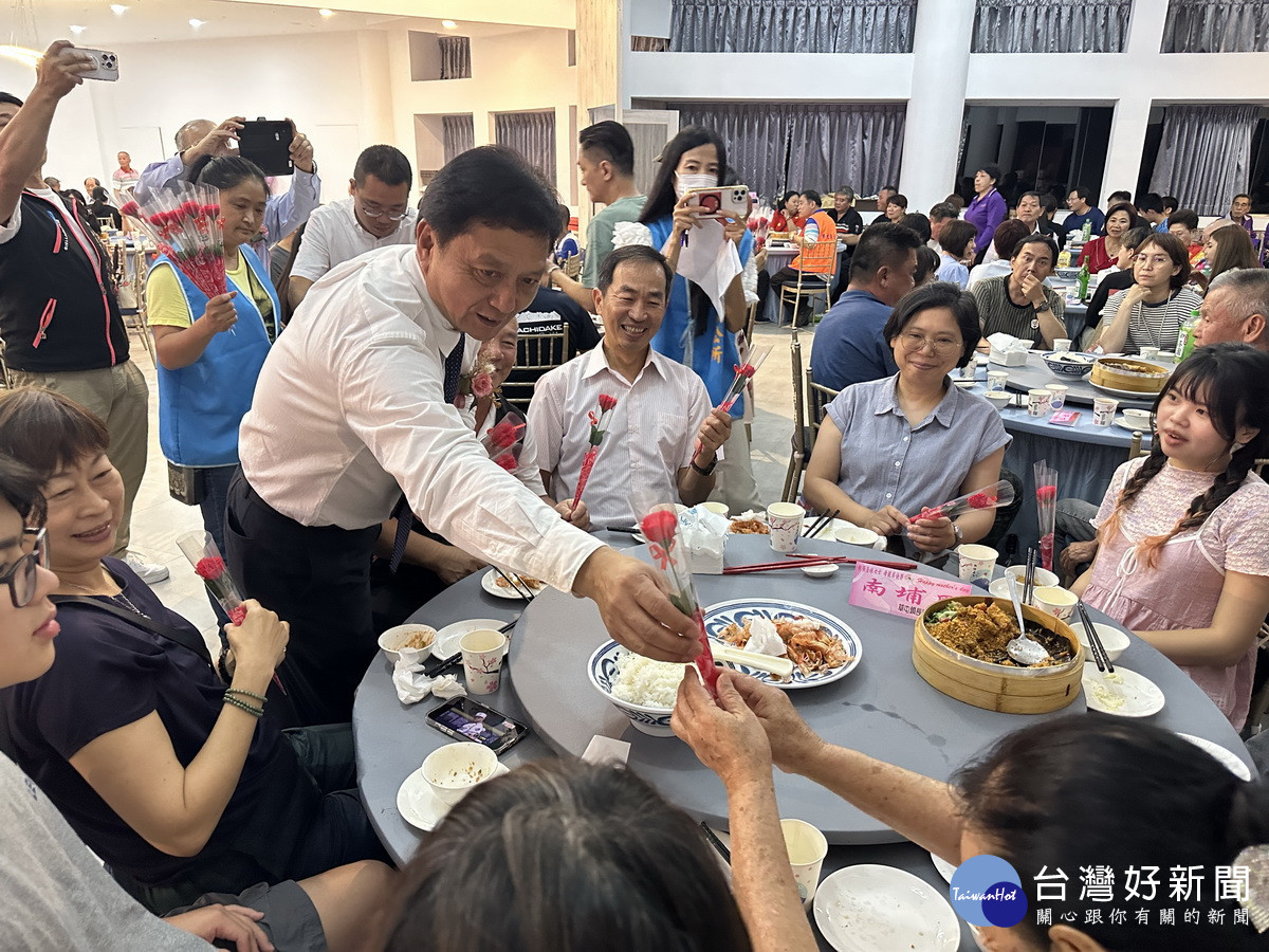簡賜勝贈花予每來賓。（記者扶小萍攝）
