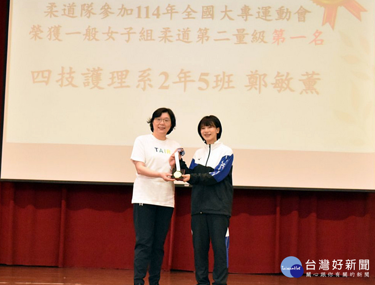 全大運獲獎的鄭敏薰(右)、劉倚岑、洪敏芳等同學們將獎牌獻給范君瑜校長(左)，表達對學校栽培的感謝