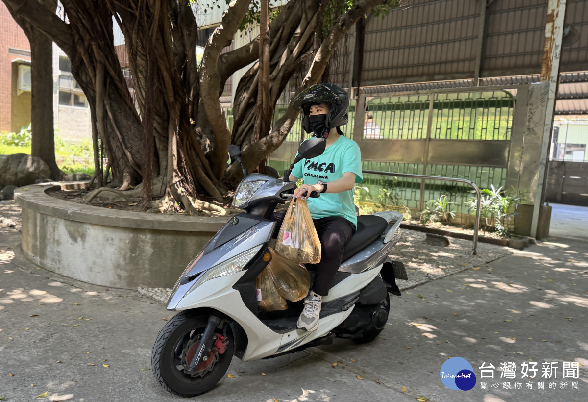 社工騎摩托車運送粽子。圖／ＹＭＣＡ提供