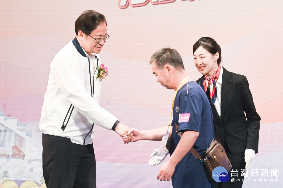 張市長與林志揚志工握手致意。