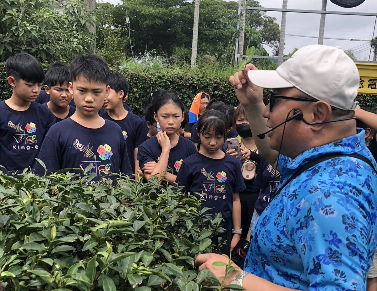 熱誠的楊國珍帶領同學參訪茶園認識茶。（TEATOP提供）<br />
