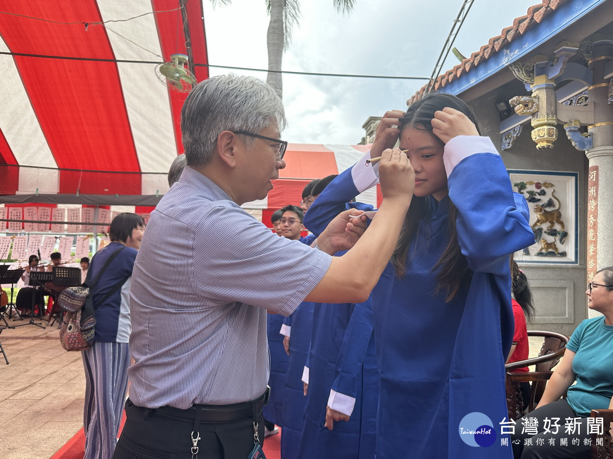 教育界代表等為青年朋友點砂賀成長。（記者扶小萍攝）<br />
