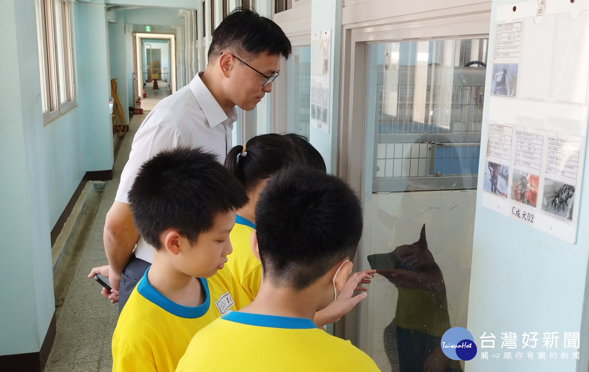動保社小朋友參訪園區犬舍，與待領養的黑犬互動