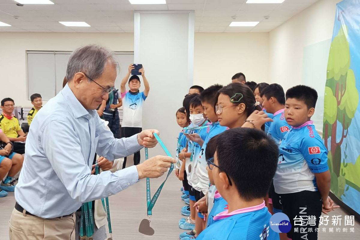 茂林光電董事長李滿祥為小騎士們佩戴完騎獎章。