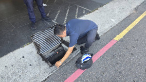 警員得俐落地將沉重的水溝蓋搬起，協助報案人順利尋回愛心悠遊卡。