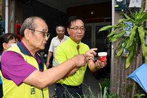 林世賢市長拿民家一個小容器提醒空的空器即使小也會積水應注意成為病媒蚊溫床。圖／記者鄧富珍翻攝