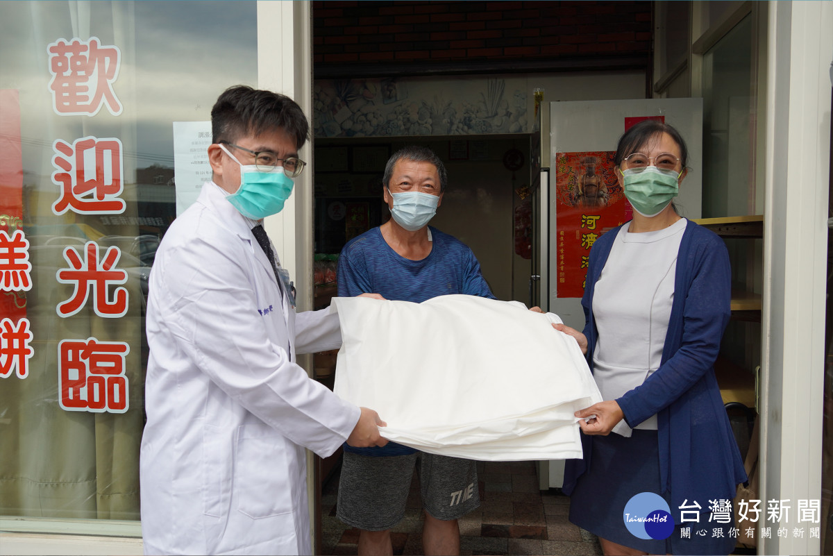 永安二路住戶永安二路經營麵包店的張先生（中）感謝鹿基致贈「科技沙包」，避免水災造成損失。圖／彰基醫院提供