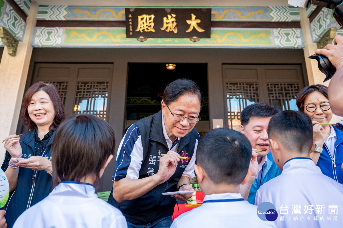 桃園市長張善政為小朋友們點硃砂，祝福他們智慧點亮、學業精進。<br />
