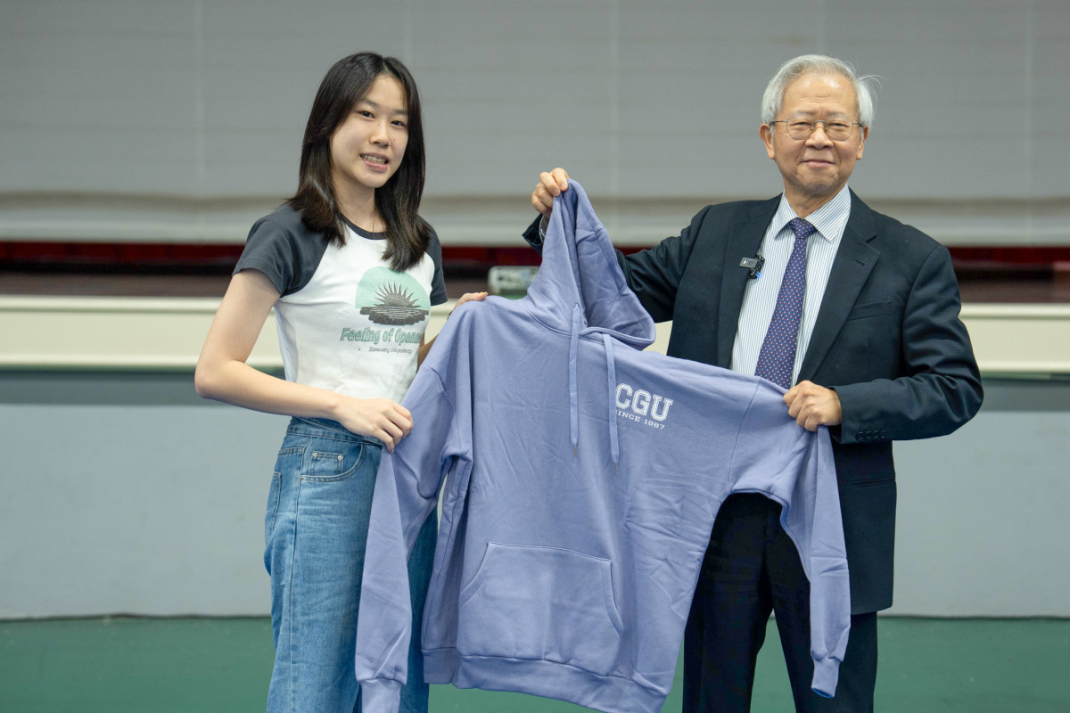 _湯明哲校長(圖右)在始業典禮上贈送印有CGU字樣的帽T給每一位新生