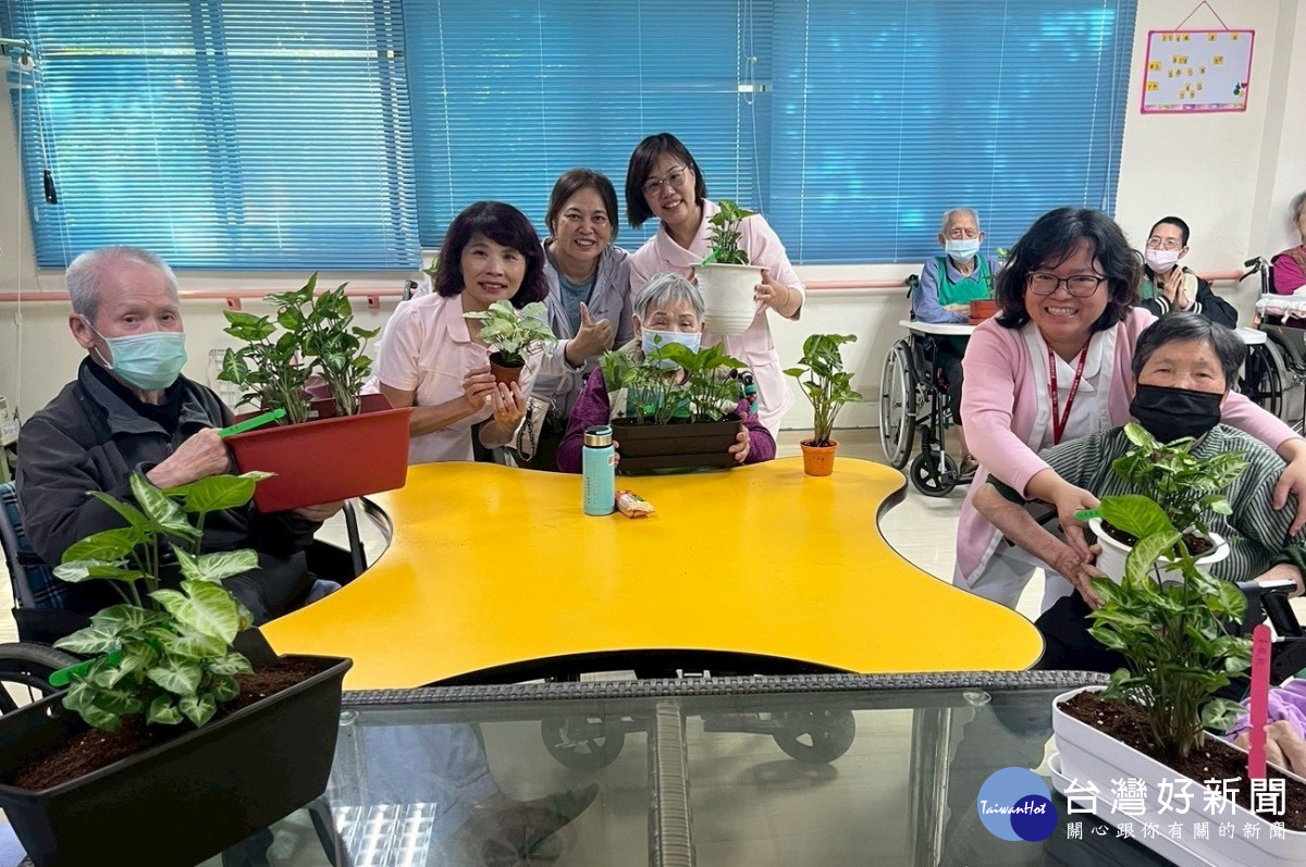 長輩完成專屬盆栽後開心展示成果，並與護理部鄭小蕙主任（左2）、鄒芳榆護理長（左4）及吳婉苓老師（左3）一同合影留念